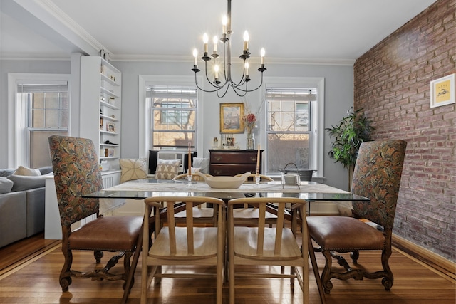 dining area with a wealth of natural light, brick wall, and hardwood / wood-style flooring