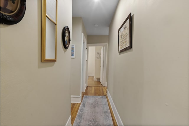 hall featuring baseboards and wood finished floors