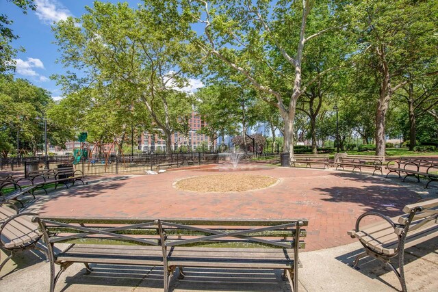view of property's community with playground community and fence