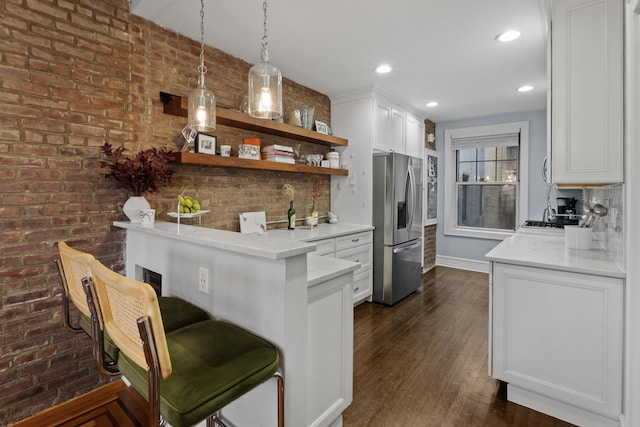kitchen with open shelves, a kitchen breakfast bar, stainless steel fridge with ice dispenser, white cabinets, and dark wood-style flooring