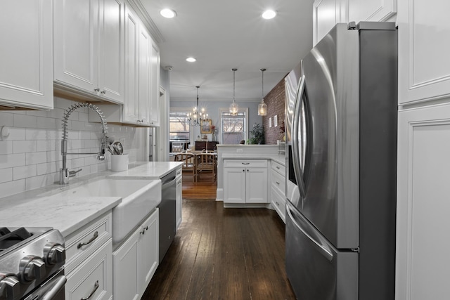 kitchen with backsplash, a notable chandelier, white cabinets, and appliances with stainless steel finishes