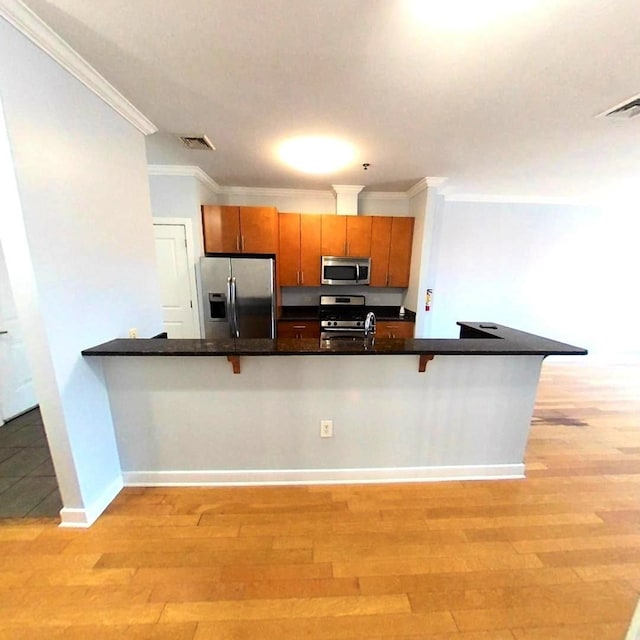 172 Culver Ave Unit 301, Jersey City, NJ 07305 - kitchen with stainless steel appliances, ornamental molding, dark countertops, brown cabinetry, and light wood-type flooring