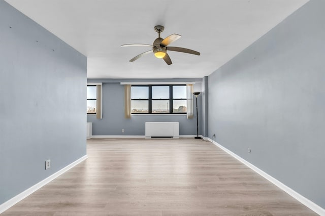 unfurnished living room featuring light hardwood / wood-style floors, radiator, and ceiling fan