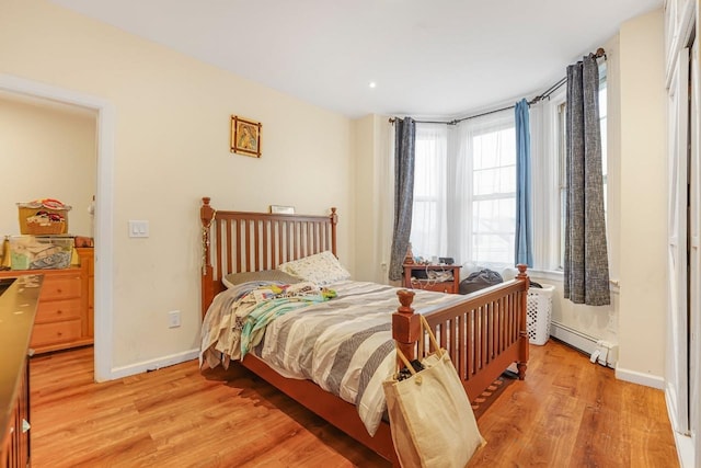1527 38th St, North Bergen, NJ 07047 - bedroom with a baseboard heating unit, light wood-type flooring, and baseboards