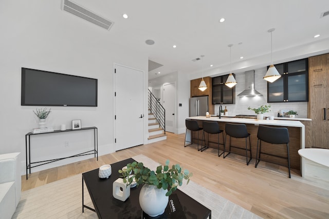 living room featuring sink and light hardwood / wood-style floors