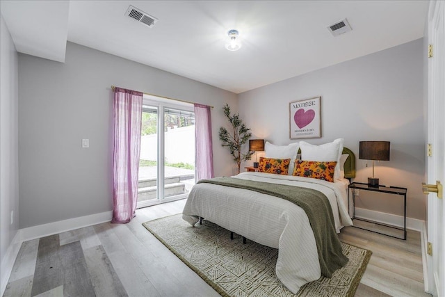 bedroom with access to exterior, visible vents, light wood finished floors, and baseboards