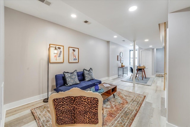 living room featuring light wood finished floors, visible vents, and recessed lighting