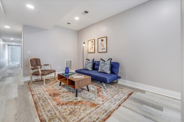 living room featuring visible vents, baseboards, and light wood-style flooring