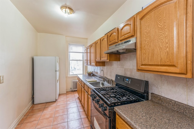 kitchen featuring light tile patterned floors, black gas range oven, sink, white refrigerator, and radiator heating unit