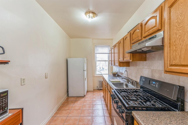 kitchen featuring black gas range, radiator heating unit, decorative backsplash, white refrigerator, and sink