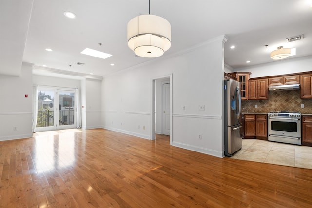 413 Madison St Unit 4, Hoboken, NJ 07030 - kitchen with stainless steel appliances, crown molding, light wood finished floors, under cabinet range hood, and decorative backsplash