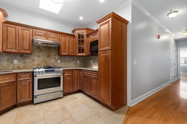 413 Madison St Unit 4, Hoboken, NJ 07030 - kitchen with stainless steel range with gas stovetop, under cabinet range hood, ornamental molding, brown cabinets, and black microwave