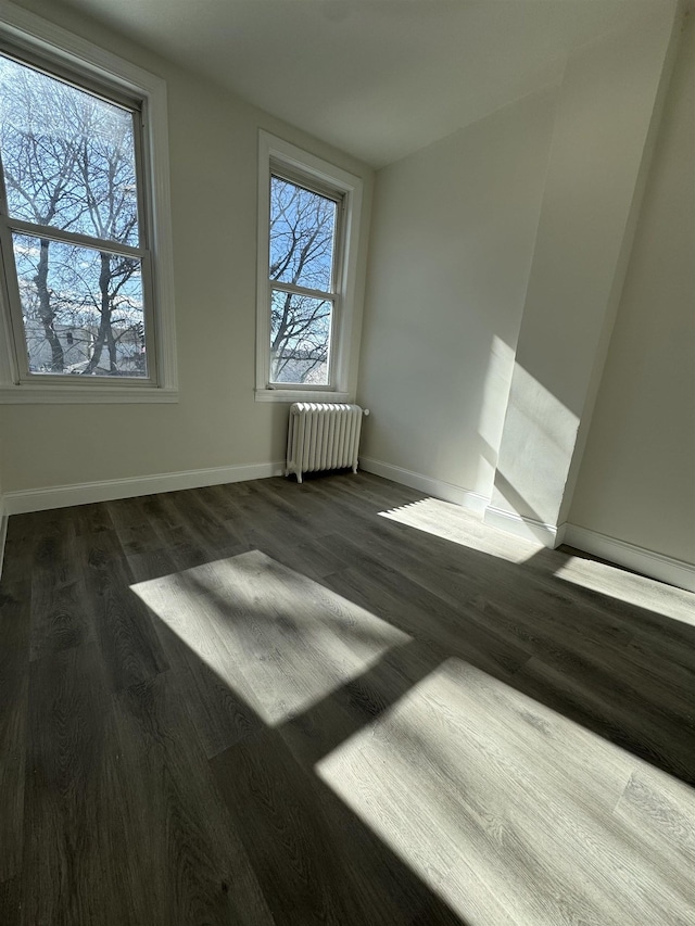 interior space featuring baseboards, dark wood finished floors, and radiator heating unit