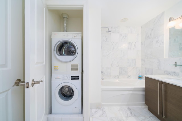 laundry room featuring stacked washer / drying machine and sink