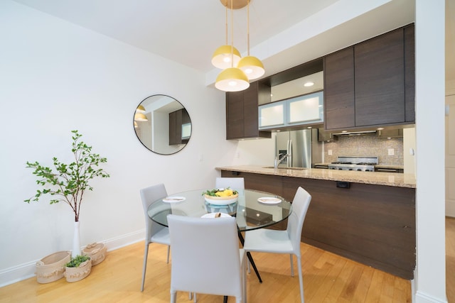 dining space featuring sink and light wood-type flooring