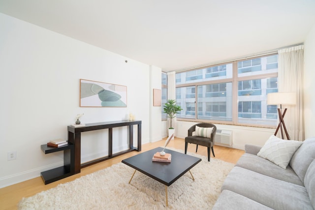 living room featuring a wall unit AC and light hardwood / wood-style floors