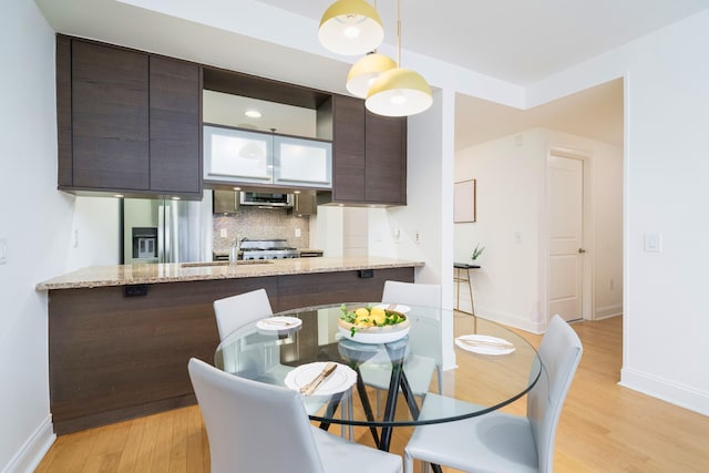 dining space with sink and light hardwood / wood-style floors