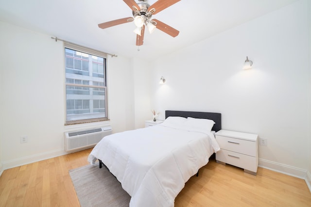 bedroom featuring an AC wall unit, ceiling fan, and light hardwood / wood-style flooring