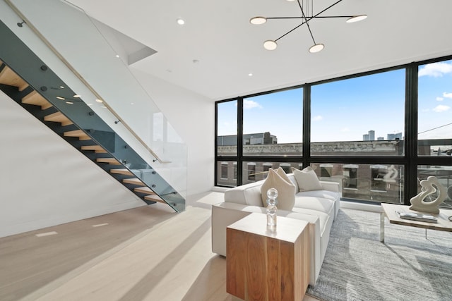 living room with floor to ceiling windows, a chandelier, and light hardwood / wood-style floors