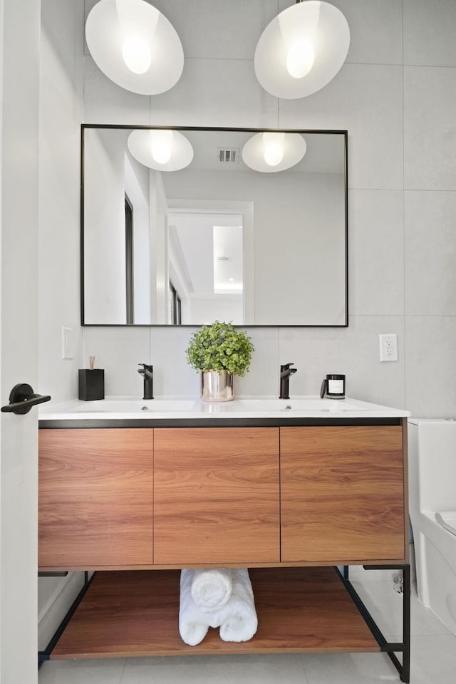 bathroom with vanity, toilet, tile walls, and backsplash