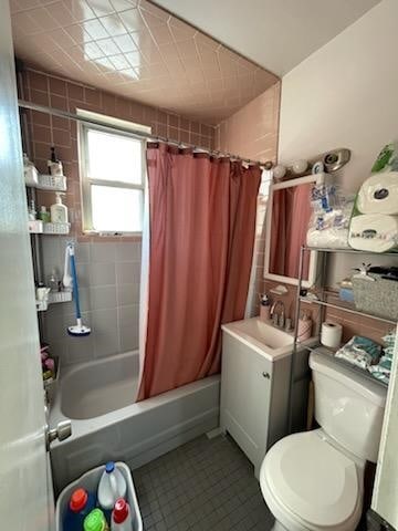 full bathroom with sink, shower / tub combo with curtain, and toilet