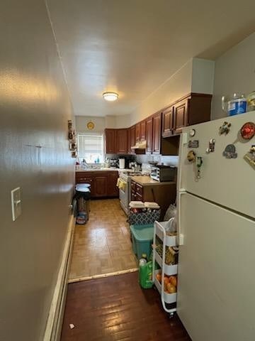 kitchen with white fridge, dark hardwood / wood-style floors, and high end stainless steel range