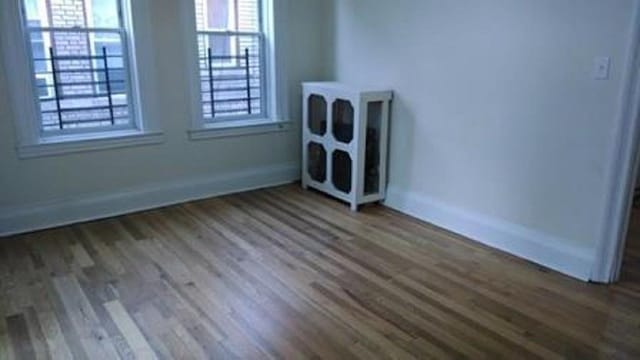 empty room featuring baseboards and wood finished floors