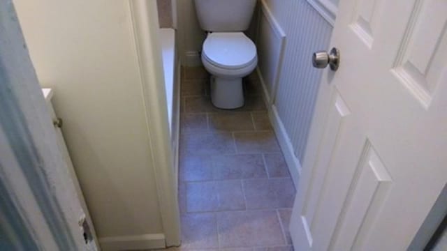 bathroom featuring toilet and baseboards
