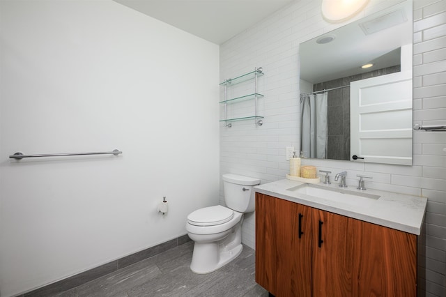 bathroom with a shower with curtain, tile walls, wood finished floors, vanity, and toilet