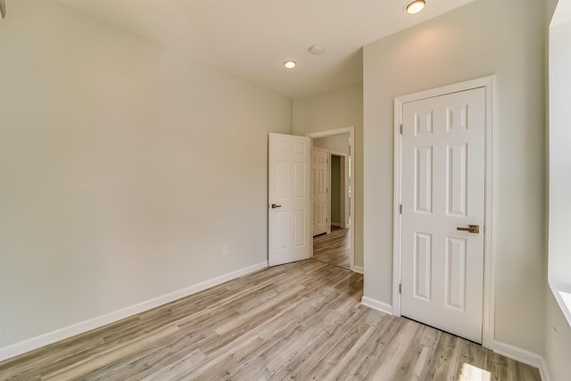 unfurnished bedroom featuring recessed lighting, light wood finished floors, and baseboards