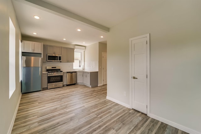 kitchen with light countertops, light wood finished floors, recessed lighting, stainless steel appliances, and decorative backsplash