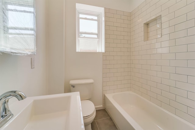 bathroom featuring toilet, tile patterned floors, and a sink
