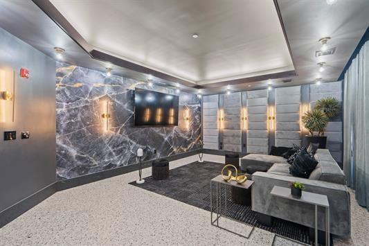 7400 River Rd Unit 304, North Bergen, NJ 07047 - cinema room featuring a raised ceiling and speckle patterned floor