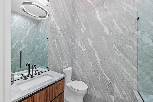 bathroom with tile walls, vanity, and toilet