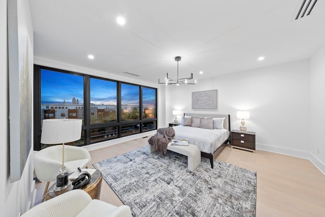 bedroom featuring a notable chandelier and light hardwood / wood-style flooring