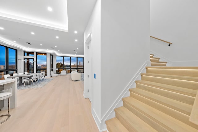 stairway featuring expansive windows and hardwood / wood-style flooring