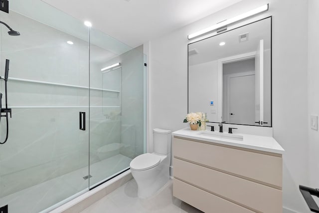 bathroom with toilet, vanity, tile patterned floors, and a shower with shower door