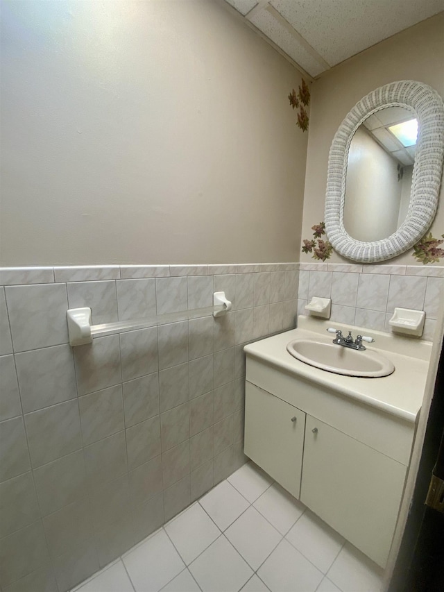 bathroom with tile patterned flooring, vanity, and tile walls