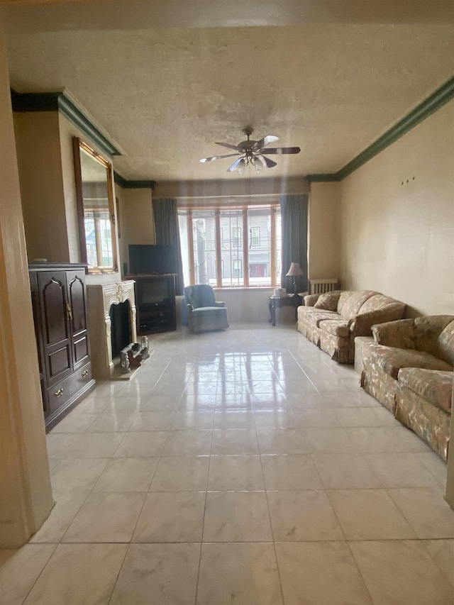 unfurnished living room with ceiling fan, ornamental molding, a textured ceiling, and a wealth of natural light