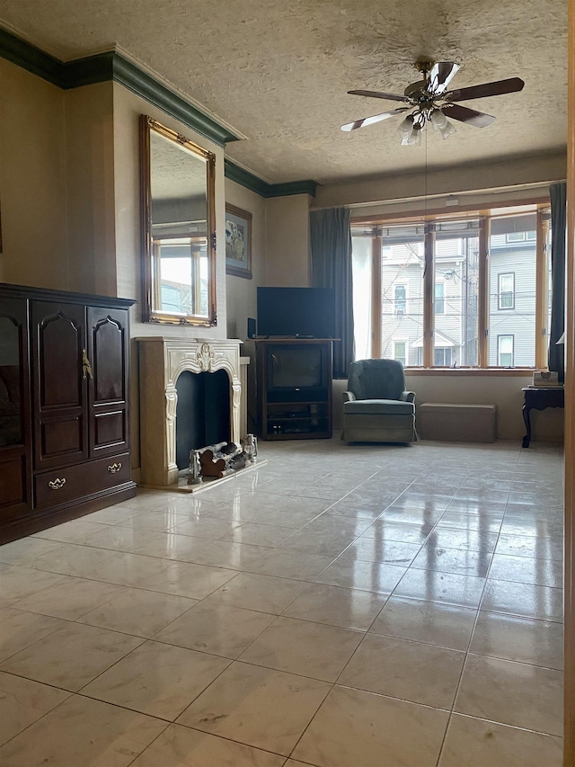 unfurnished living room featuring light tile patterned flooring, ceiling fan, ornamental molding, and a textured ceiling