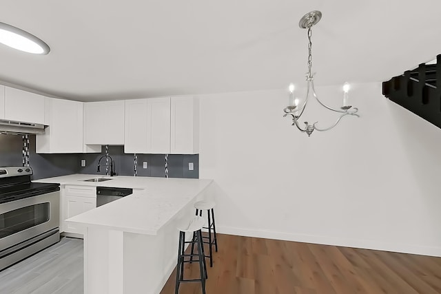 90 Ralph St Unit 3, Belleville, NJ 07109 - kitchen with stainless steel appliances, a sink, a chandelier, a kitchen breakfast bar, and white cabinets