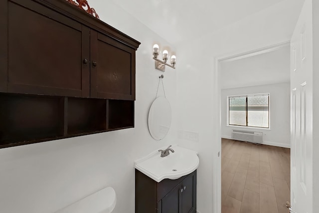 90 Ralph St Unit 3, Belleville, NJ 07109 - bathroom featuring vanity, a wall unit AC, toilet, wood finished floors, and baseboards