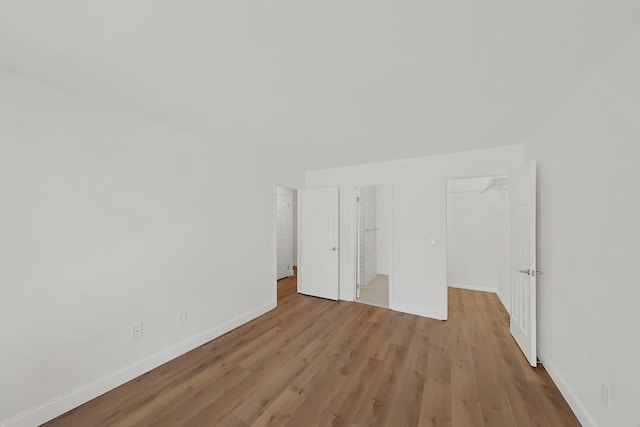 90 Ralph St Unit 3, Belleville, NJ 07109 - unfurnished bedroom with baseboards, light wood finished floors, a walk in closet, and a closet