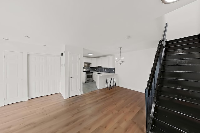 90 Ralph St Unit 3, Belleville, NJ 07109 - unfurnished living room with a chandelier, stairs, light wood finished floors, baseboards, and recessed lighting
