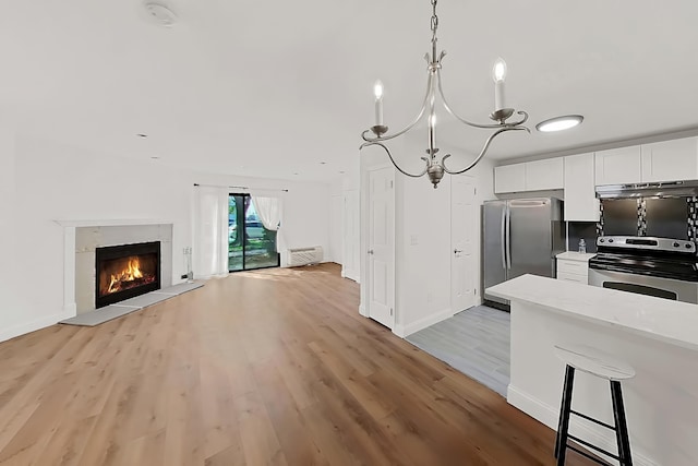 90 Ralph St Unit 3, Belleville, NJ 07109 - kitchen with appliances with stainless steel finishes, light wood finished floors, under cabinet range hood, white cabinetry, and a chandelier
