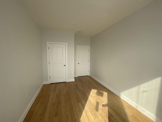 unfurnished bedroom featuring wood finished floors and baseboards