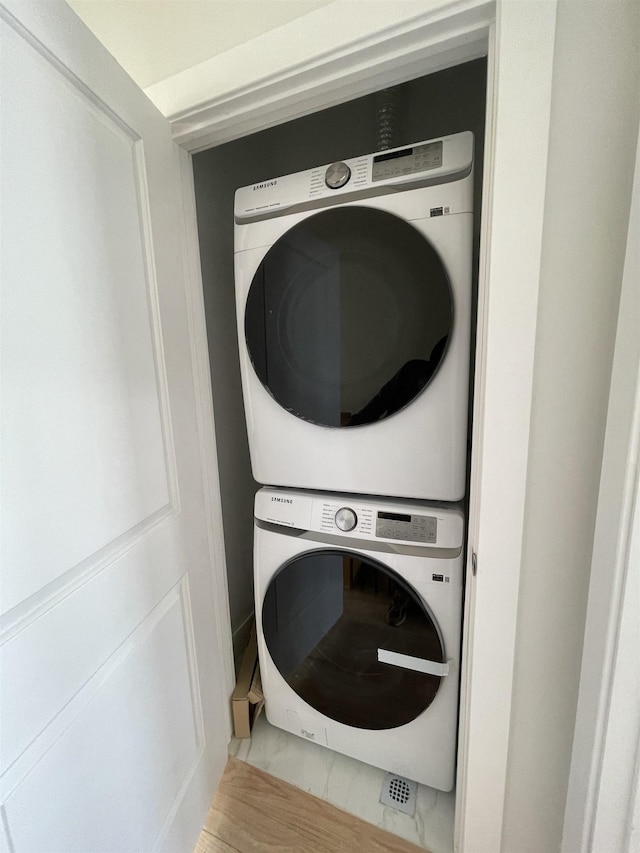 clothes washing area featuring stacked washer / drying machine and laundry area