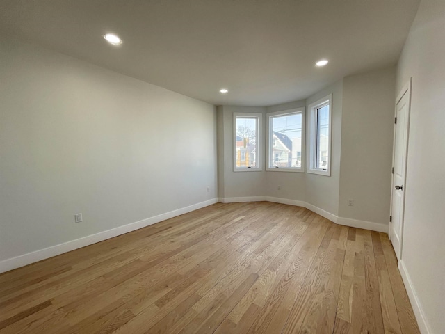 empty room with recessed lighting, light wood-style flooring, and baseboards