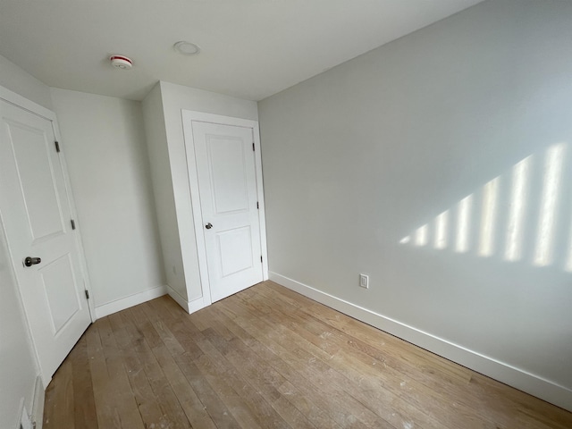 unfurnished bedroom with light wood-style floors and baseboards