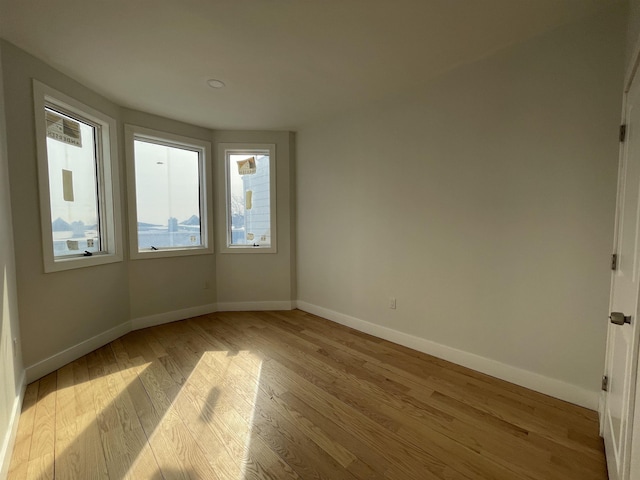 empty room with light wood-style floors and baseboards